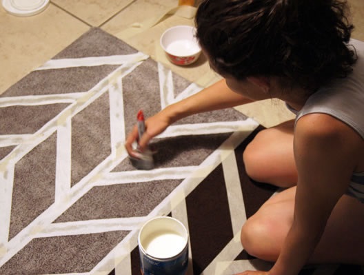 chica decorando un tapete con pintura